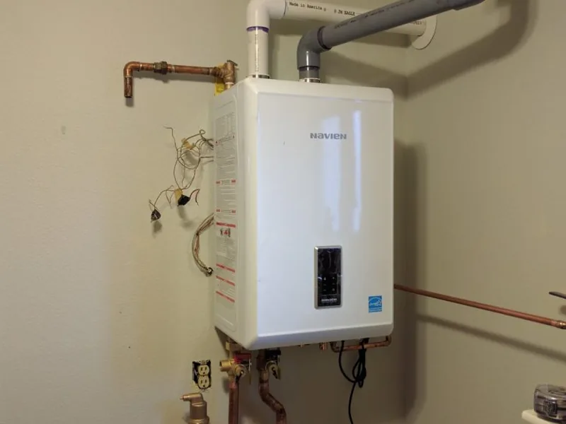 Technician diagnosing a leaking tankless water heater in San Tan Valley, AZ 85140