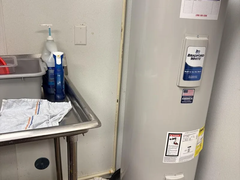Water heater sitting centered in a properly sized drain pan in a Eloy attic