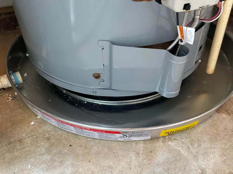 New aluminum drain pan installed under a tank water heater in a Sun Lakes home